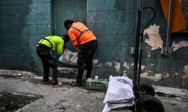Workers put bags of sand at the back door of a shop on June 30 in preparation for the arrival of Hurricane Beryl in Bridgetown