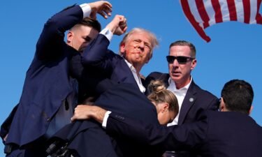 Former President Donald Trump is surrounded by U.S. Secret Service agents after he was shot at a campaign rally on July 13