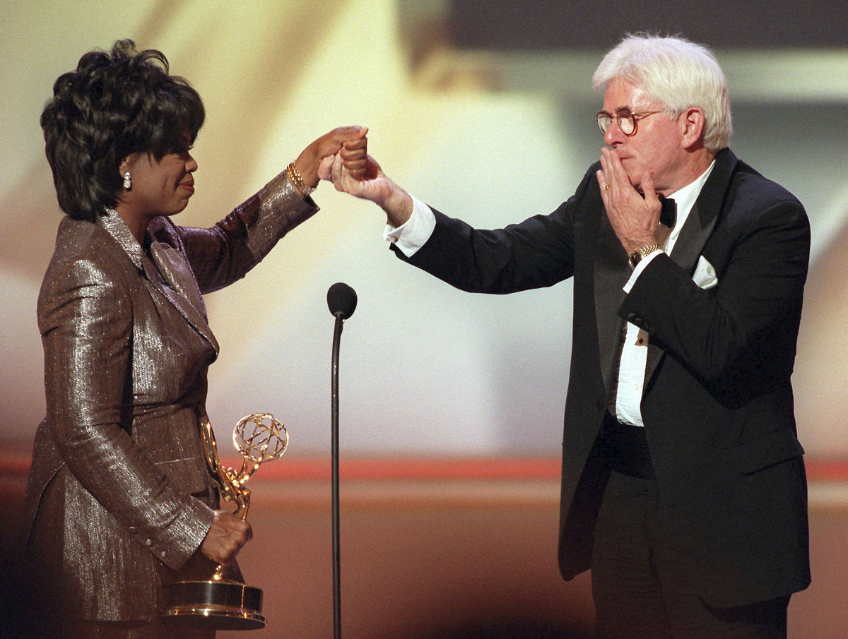 FILE - Phil Donahue blows a kiss to Oprah Winfrey as she presents him with a Lifetime Achievement Award at the 23rd Annual Daytime Emmy Awards in New York Wednesday, May 22, 1996. Donahue, whose pioneering daytime talk show launched an indelible television genre, has died. He was 88.