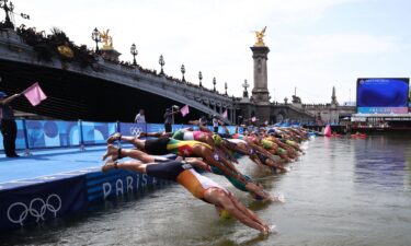 Athletes dive into the River Seine to start the swimming stage of the men's individual triathlon at the Paris 2024 Olympic Games on July 31.