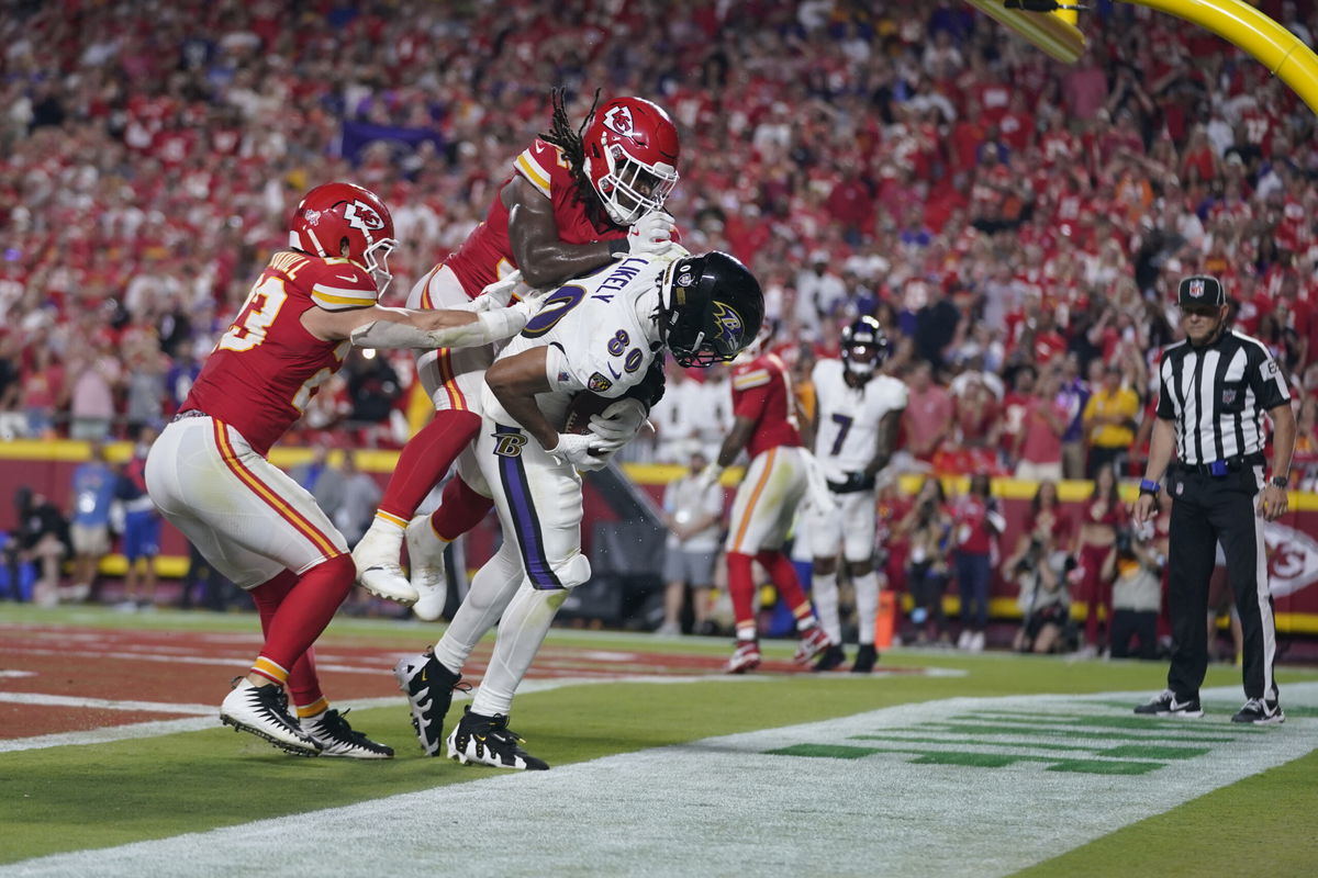 Baltimore Ravens tight end Isaiah Likely (80) catches a pass with his toe out of bounds as Kansas City Chiefs linebacker Nick Bolton and linebacker Drue Tranquill, left, defend as time time expires in the second half of an NFL football game Thursday, Sept. 5, 2024, in Kansas City, Mo. The Chiefs won 27-20.(AP Photo/Ed Zurga)