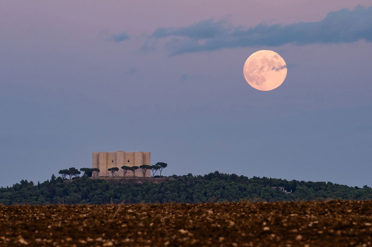 The full hunter's moon rises behind Castel del Monte in Andria, Italy, on October 28, 2023.
