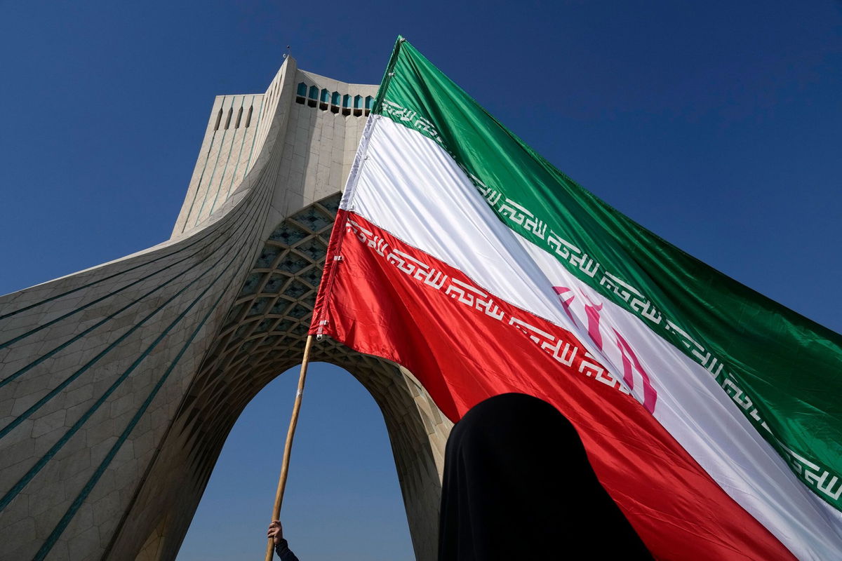 An Iranian flag is carried under the Azadi (Freedom) monument tower in Tehran, Iran, on Sunday, February 11. 
