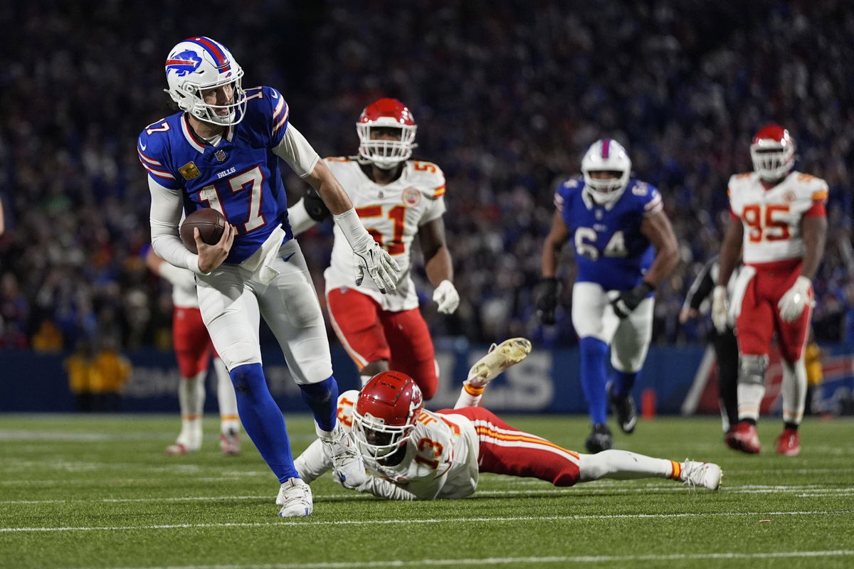 Buffalo Bills quarterback Josh Allen (17) slips past Kansas City Chiefs cornerback Nazeeh Johnson (13) to score on a 26-yard run during the second half of an NFL football game Sunday, Nov. 17, 2024, in Orchard Park, N.Y. 