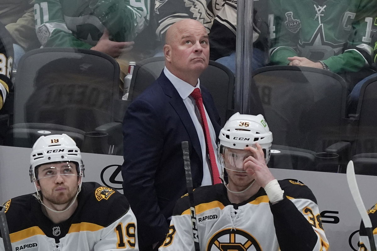 FILE - Boston Bruins head coach Jim Montgomery looks on from the bench with centers John Beecher (19) and Patrick Brown (38) during the first period of an NHL hockey game against the Dallas Stars, Nov. 14, 2024, in Dallas. 