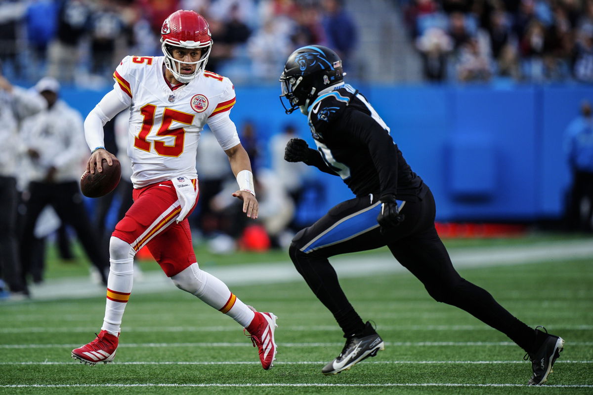 Kansas City Chiefs quarterback Patrick Mahomes (15) runs agaimnst Carolina Panthers linebacker Charles Harris (40) during the second half of an NFL football game, Sunday, Nov. 24, 2024, in Charlotte, N.C. 