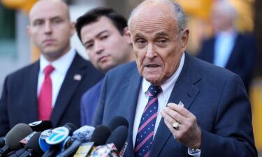 Former New York Mayor Rudy Giuliani speaks the media as he leaves court in New York on November 7.