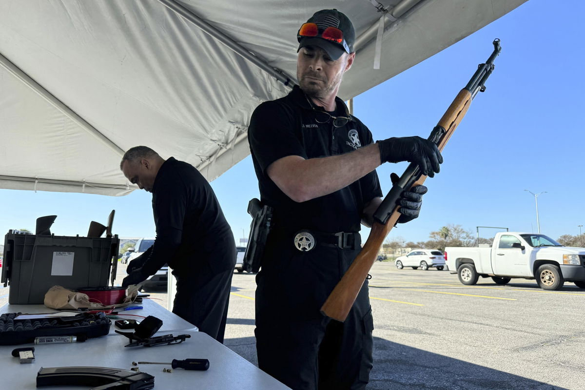 New Orleans police officer John Mciver dismantles a firearm handed over as part of a city-supported initiative exchanging guns for PlayStations, Tuesday, Dec. 31, 2024, in New Orleans. 