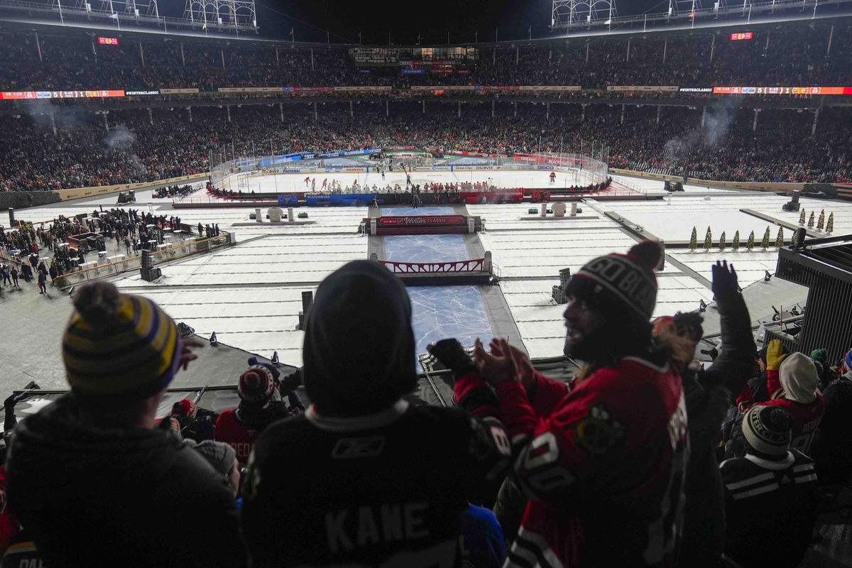 Fans celebrate after a goal by the Chicago Blackhawks against the St. Louis Blues during the third period of the NHL Winter Classic outdoor hockey game at Wrigley Field, Tuesday, Dec. 31, 2024, in Chicago. 