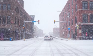 A car slides around a corner amid snow in Des Moines