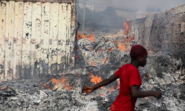 People try to salvage items after the fire at the Kantamanto market