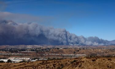 A cloud of smoke from the Hughes Fire rises as firefighters and aircraft battle it near Castaic Lake