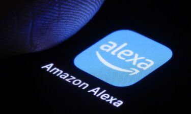 In this photo illustration the logo of Amazon Alexa can be seen next to a finger on a smartphone on January 3 in Berlin