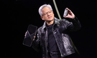 Nvidia CEO Jensen Huang holds a new Nvidia GeForce RTX 5090 graphics card as he gives a keynote address at CES 2025