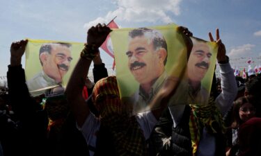 Supporters of pro-Kurdish Peoples' Equality and Democracy Party display flags with a portrait of jailed Kurdistan Workers' Party leader