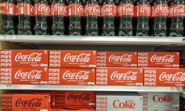 Coca-Cola cans move down a conveyer belt in a bottling plant on October 20