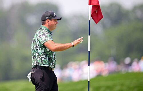 Patrick Reed picks up his ball after carding an albatross on the par-5 fourth at Oakmont Country Club.